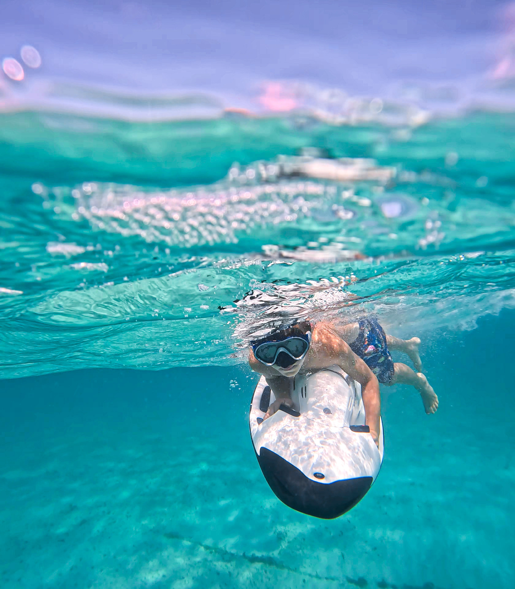 A child riding a white SEABOB underwater in Saint-Barthélemy